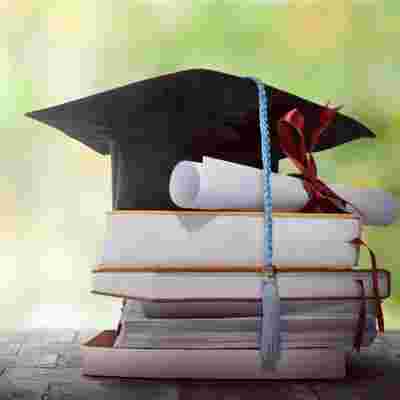 Graduation Hat With Degree Paper On A Stack Of Book